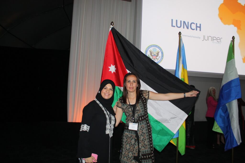 Hanan Khader poses with a fellow Jordanian Emerging Leader in front of their national flag. 