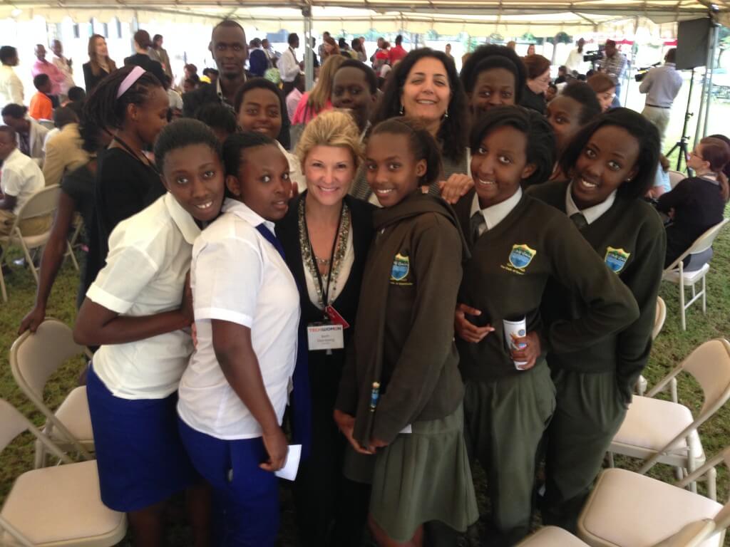 Beth Steinberg, a TechWomen Mentor from Genentech, and Salima Fassil, a TechWomen Mentor from Twitter, pose for a photo with secondary schoolgirls at a career fair in Kigali. 